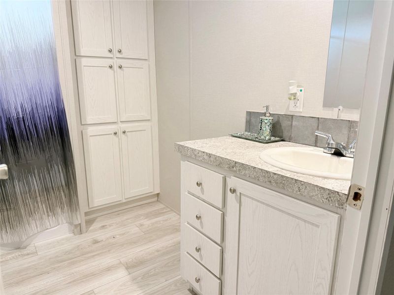 A well-appointed bathroom features a practical vanity and ample storage cabinetry.