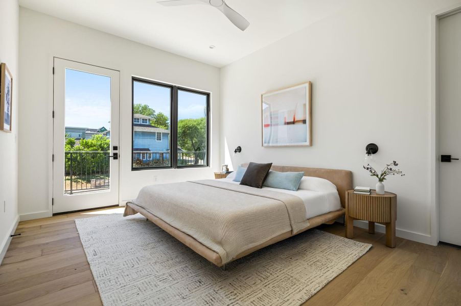 Rich hardwood flooring and abundant natural light define this serene bedroom setting.