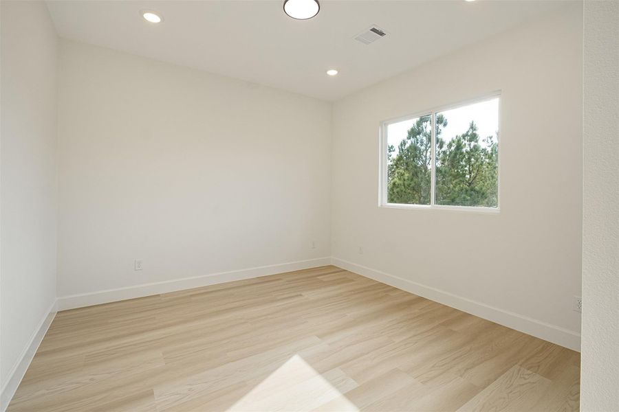 Spare room with light wood finished floors and recessed lighting