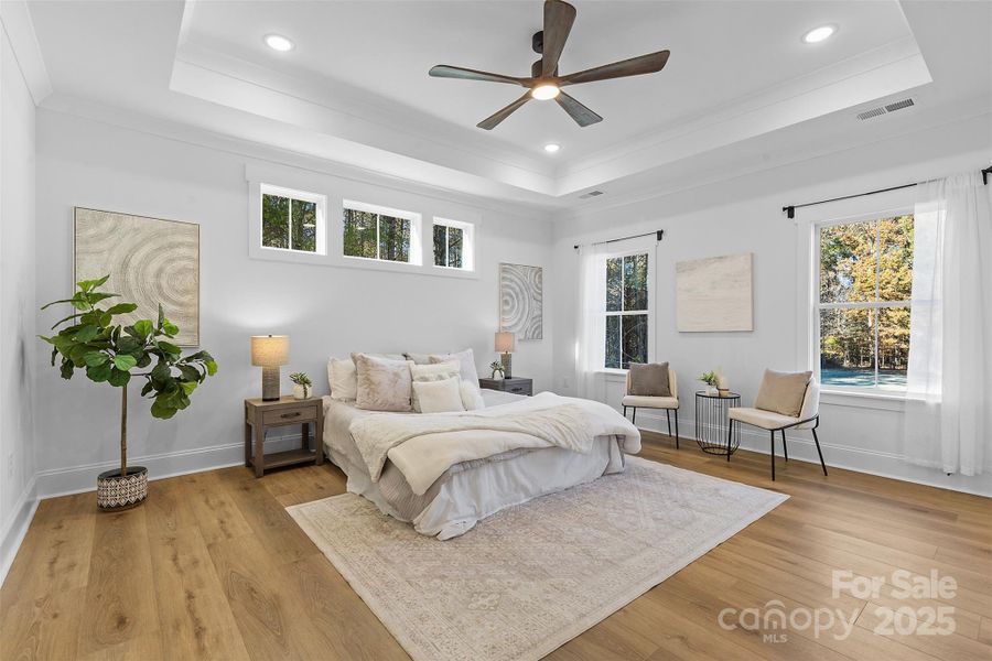*representative photo- primary bedroom w/ tray ceiling, additional windows for natural light, ensuite bathroom, and a private access to the covered back porch!