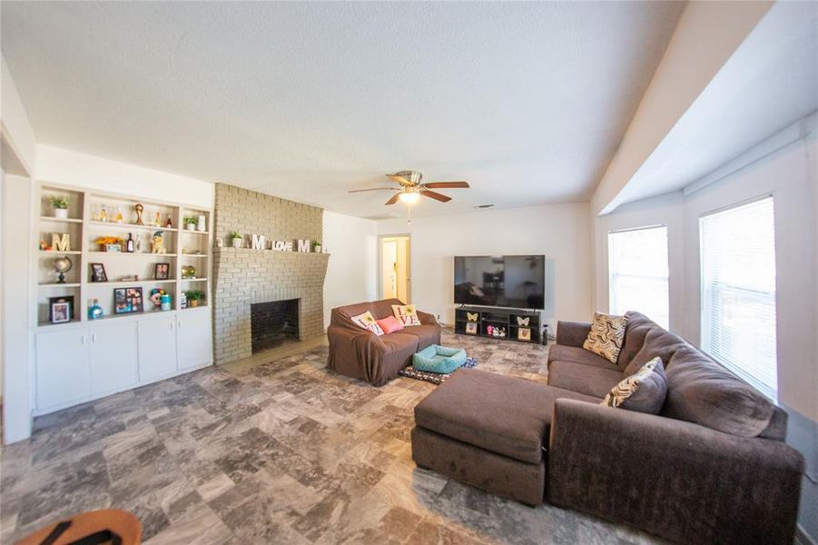 Living area with a fireplace and ceiling fan