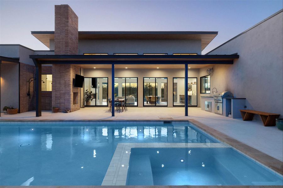 View of pool featuring exterior kitchen, a patio area, and a pool with connected hot tub