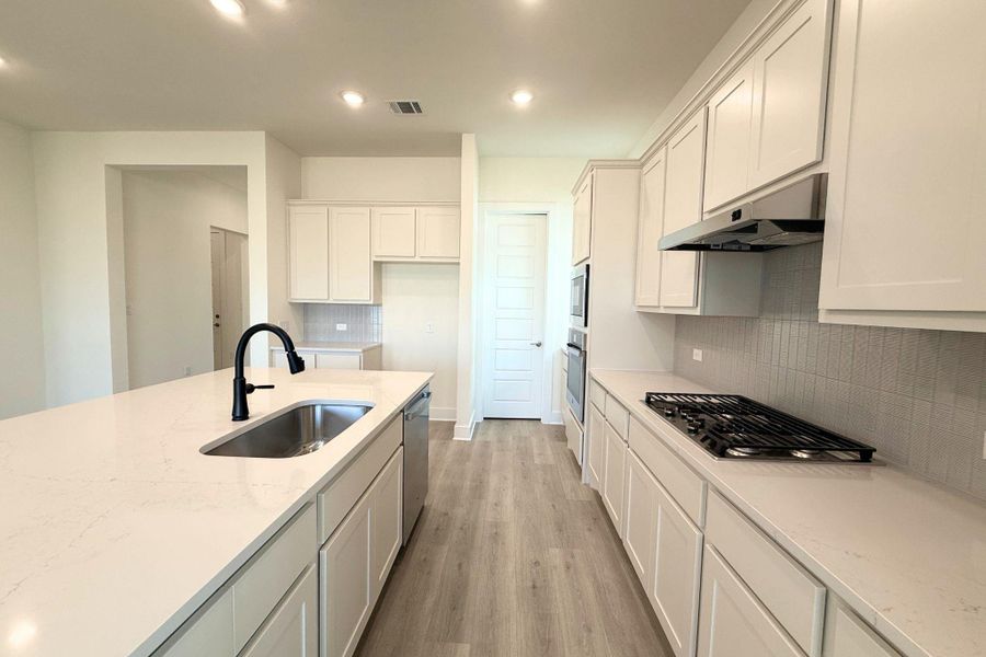 A well-appointed culinary space featuring ample counter surfaces and modern appliances. A well-appointed culinary space featuring ample counter surfaces and modern appliances.