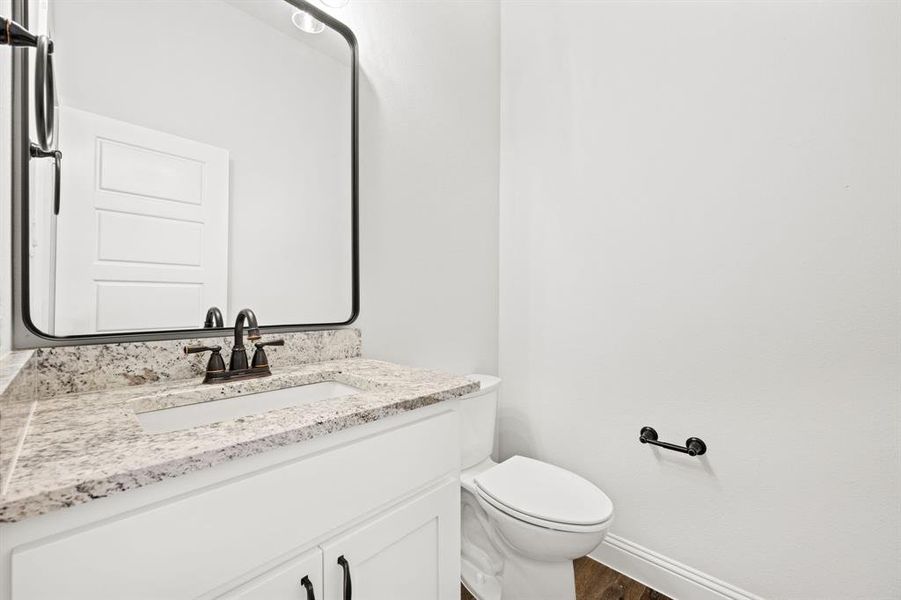 Bathroom featuring toilet, vanity, and hardwood / wood-style flooring