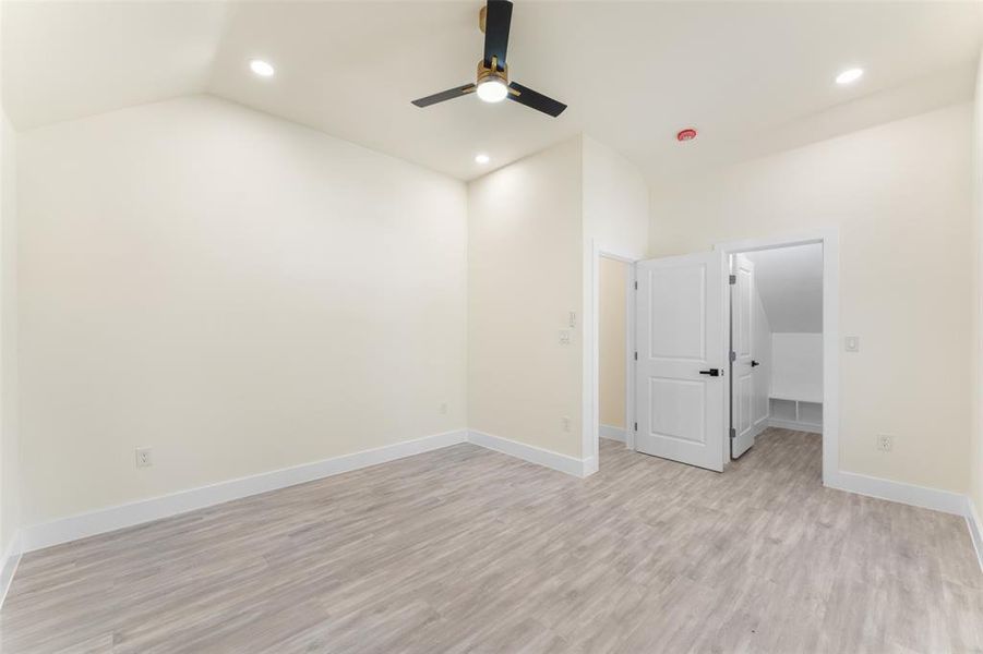Spare room featuring lofted ceiling, ceiling fan, recessed lighting, and light wood-type flooring