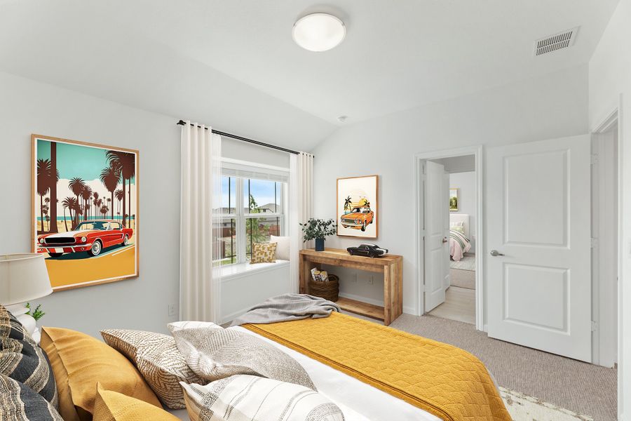 Bedroom with yellow bedding, vaulted ceiling, carpet floors, and open door to ensuite bathroom