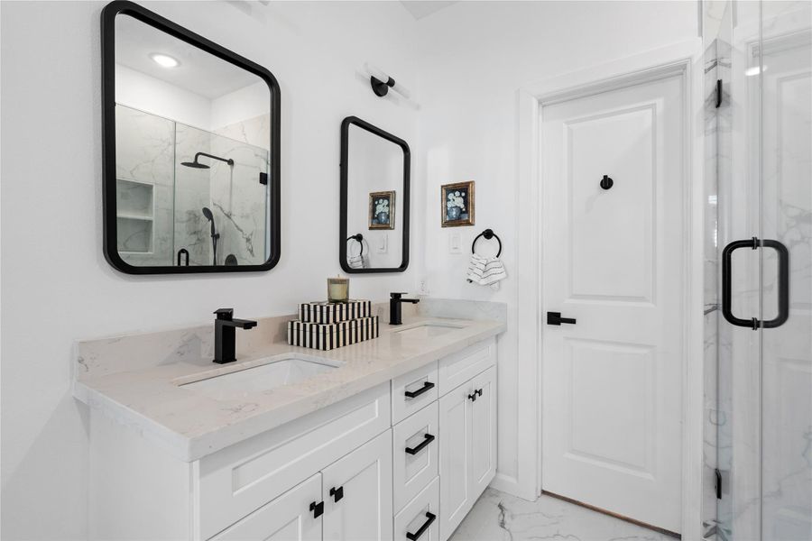 Dual sinks and quartz counters end the morning shuffle; black hardware and sculpted mirrors add that “designer” feel on a smart budget. Dual sinks and quartz counters end the morning shuffle; black hardware and sculpted mirrors add that “designer” feel on a smart budget.