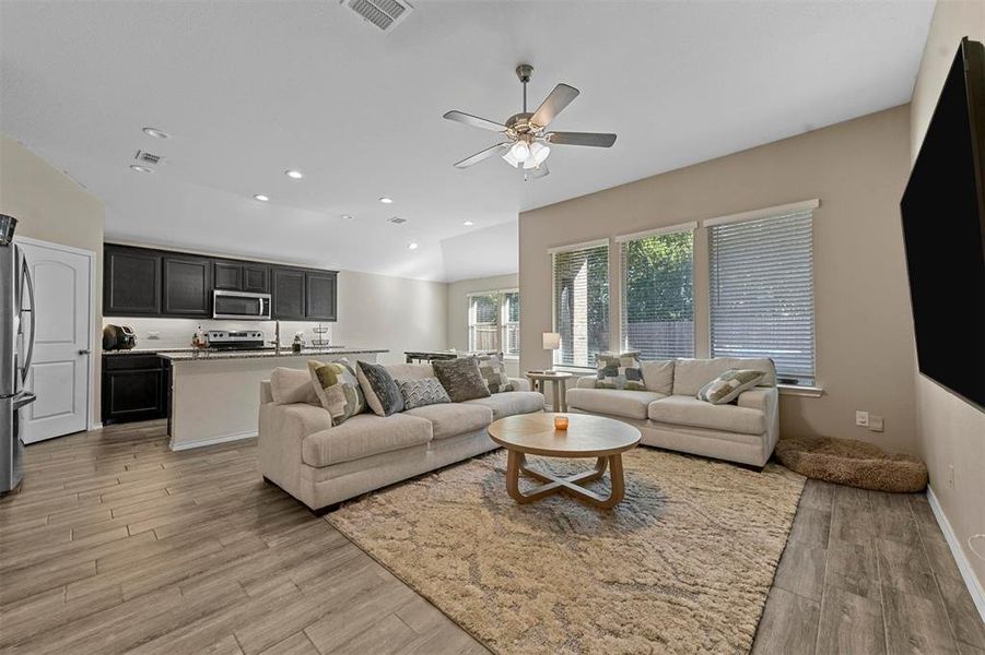 Living room with light hardwood / wood-style floors and ceiling fan