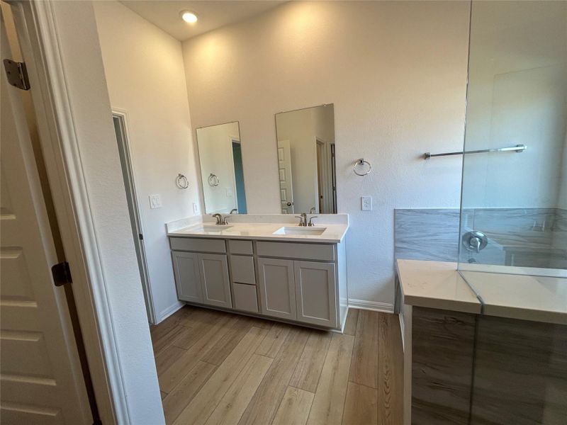 Full bath featuring light wood-type flooring and double vanity Full bath featuring light wood-type flooring and double vanity
