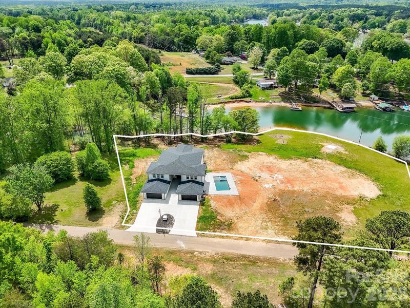 Aerial view of the property showcasing its prime location on a peaceful cove just off Lake Norman with expansive surrounding land.