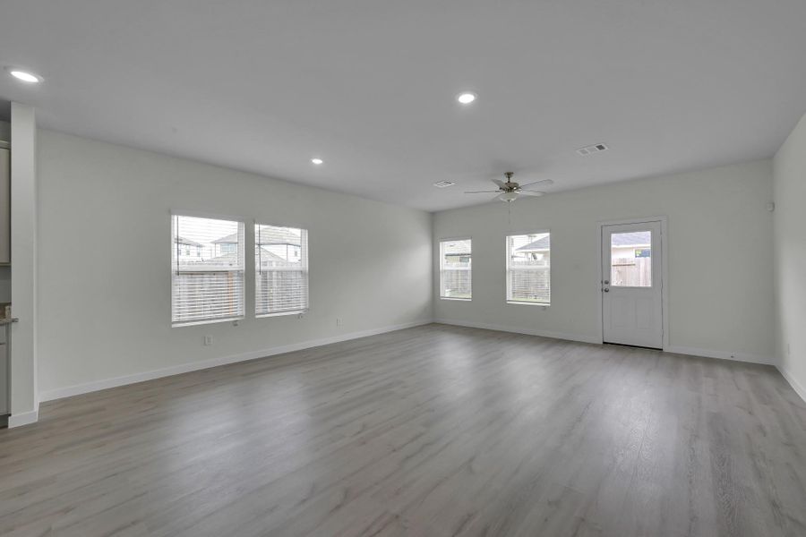 Expansive living area featuring updated flooring, fresh paint, and abundant natural light. Expansive living area featuring updated flooring, fresh paint, and abundant natural light.