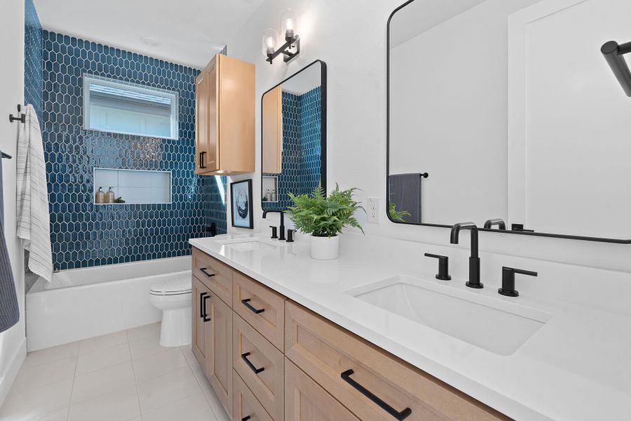 Bathroom with tile patterned flooring, toilet, bathing tub / shower combination, and a sink