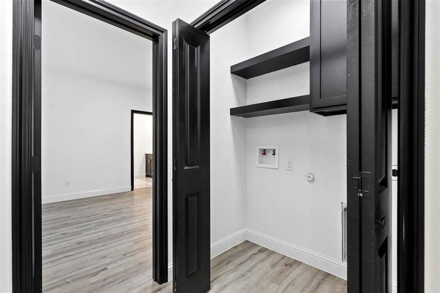 Laundry area featuring light hardwood / wood-style floors and hookup for a washing machine