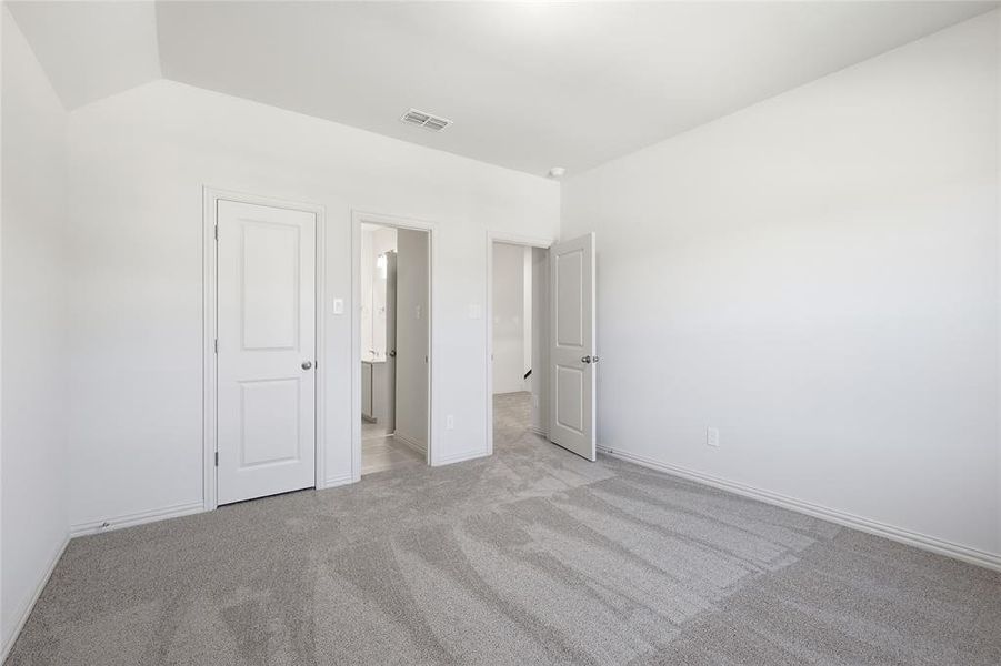 Unfurnished bedroom with light colored carpet and baseboards Unfurnished bedroom with light colored carpet and baseboards