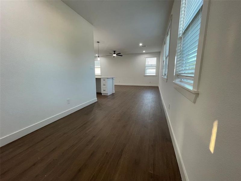 Unfurnished living room featuring dark wood-style floors, ceiling fan, and recessed lighting Unfurnished living room featuring dark wood-style floors, ceiling fan, and recessed lighting