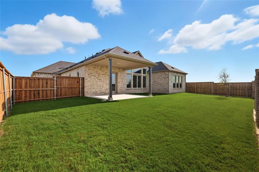 Back of house with a patio area, a fenced backyard, brick siding, and a shingled roof Back of house with a patio area, a fenced backyard, brick siding, and a shingled roof