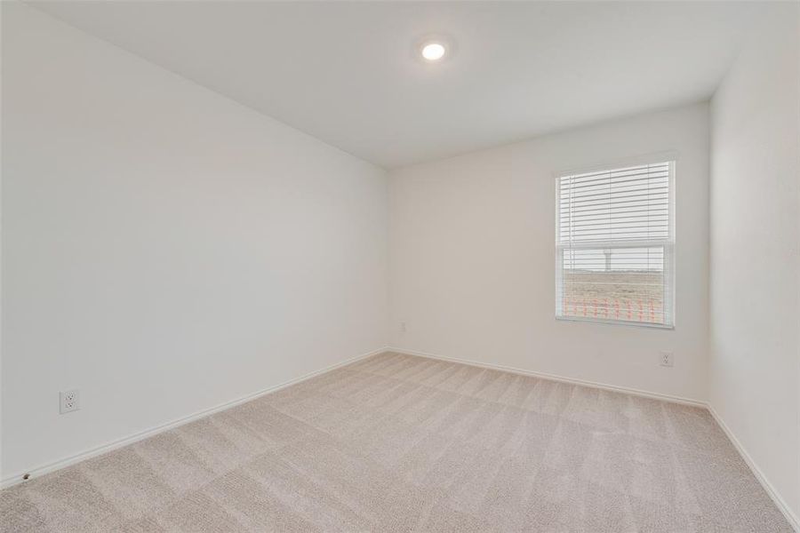 Empty room featuring light colored carpet