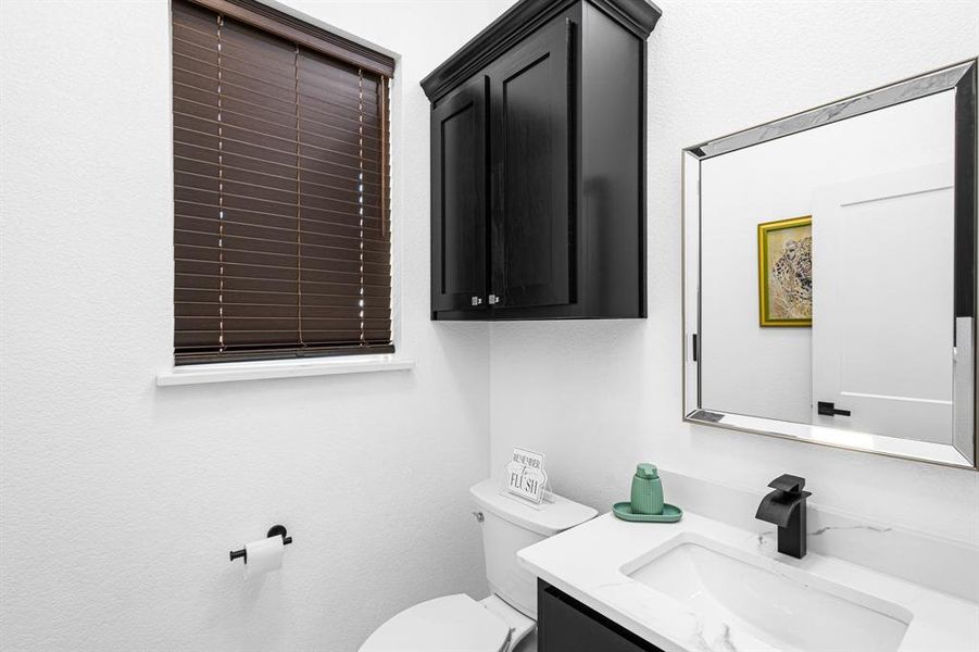 Half bath with vanity and a textured wall