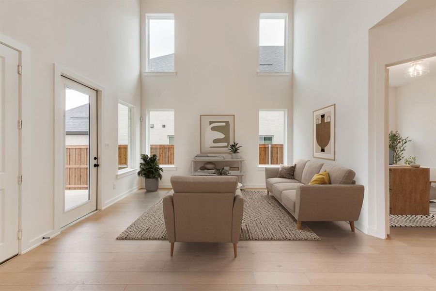 Living room with a towering ceiling and light wood finished floors Living room with a towering ceiling and light wood finished floors