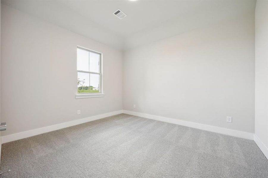 Empty room featuring light colored carpet and baseboards