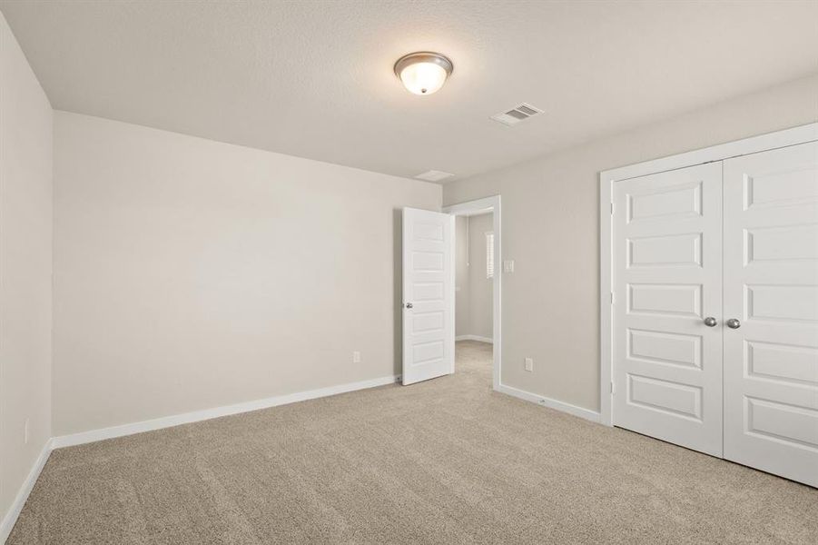 An additional view of the Stunning Secondary bedroom on second floor which features plush carpet, oversized window and double-door closet.