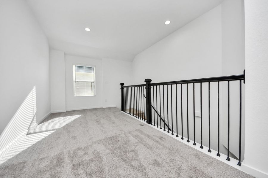 Come upstairs and enjoy a day of leisure in this fabulous game room! This is the perfect hangout spot or adult game room! Features plush carpet, high ceilings, custom paint and windows for plenty of natural light. Sample photo of completed home with similar floor plan. Actual colors and selections may vary.