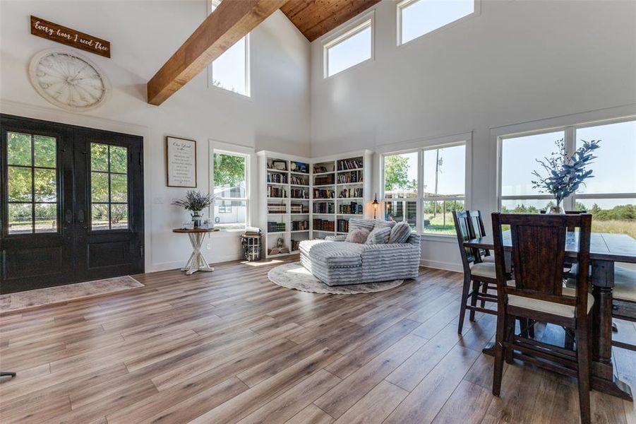 Living room with a wealth of natural light, beam ceiling, french doors, and hardwood / wood-style flooring Living room with a wealth of natural light, beam ceiling, french doors, and hardwood / wood-style flooring