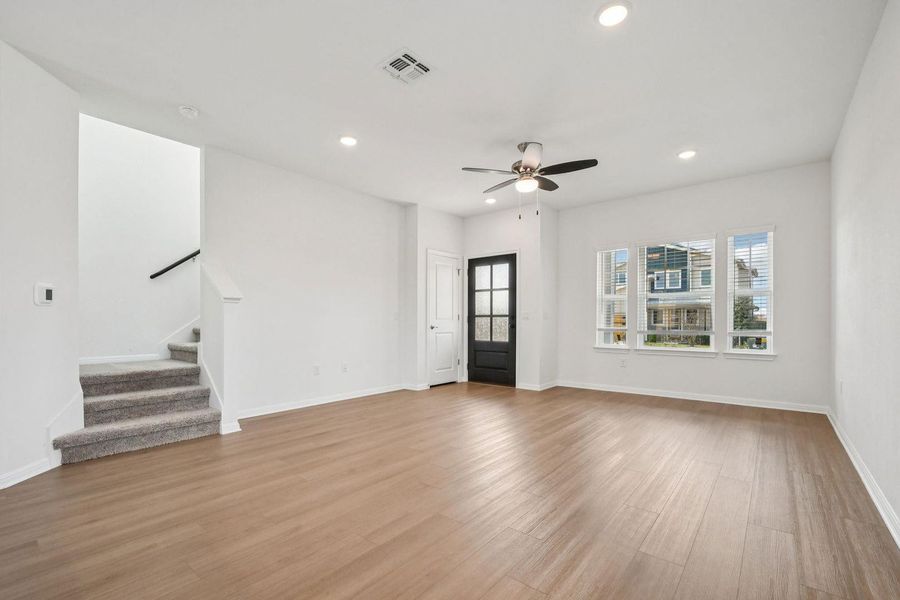Unfurnished living room with stairs, recessed lighting, light wood-type flooring, and a ceiling fan