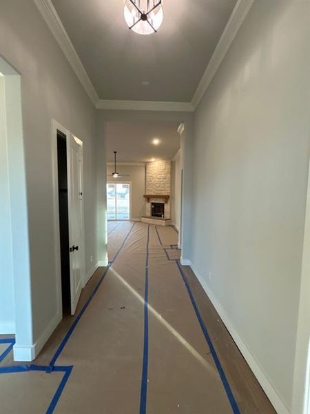 Corridor featuring baseboards and crown molding