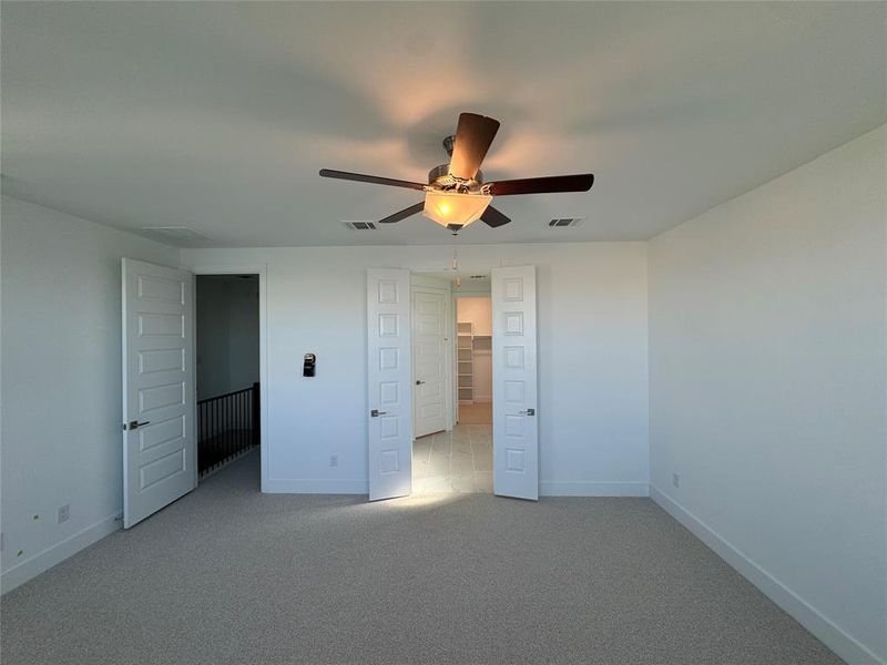 Unfurnished bedroom with ceiling fan and light carpet