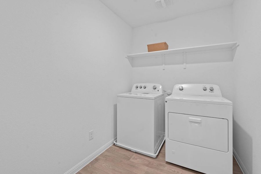Laundry room with light wood-style floors and independent washer and dryer Laundry room with light wood-style floors and independent washer and dryer