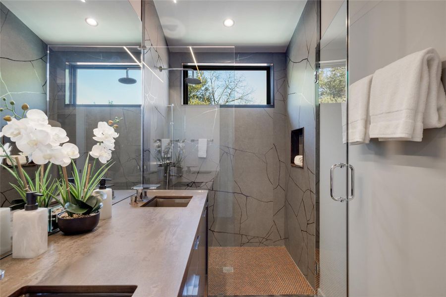 Owners Ensuite bathroom featuring vanity and curated stone and glass