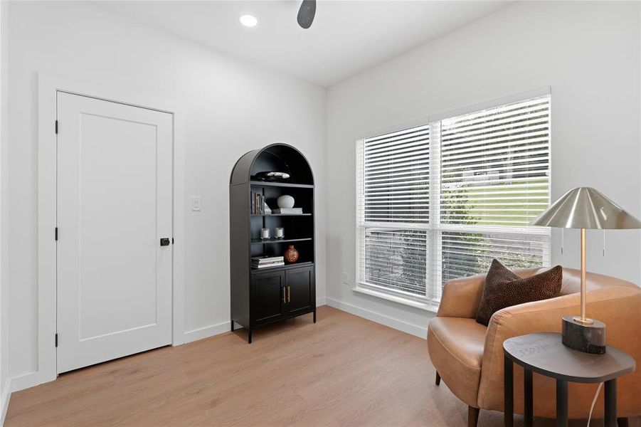 Bright interior space featuring wood-finish flooring, a large window with horizontal blinds, a ceiling fan, and recessed lighting