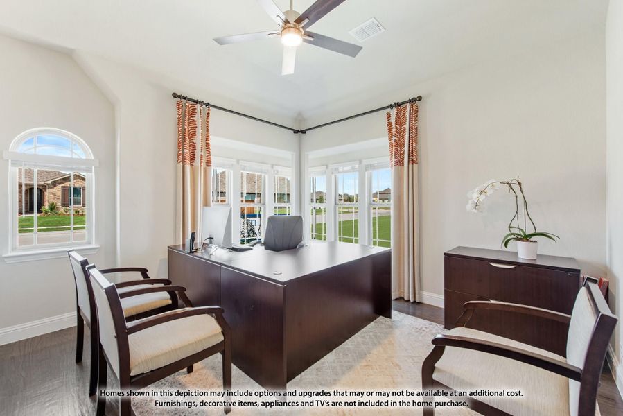 Home office with dark wood desk, ceiling fan, and large windows overlooking yard Home office with dark wood desk, ceiling fan, and large windows overlooking yard