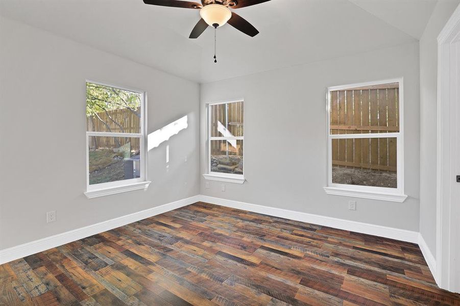 Unfurnished room featuring ceiling fan, lofted ceiling, and dark hardwood / wood-style flooring