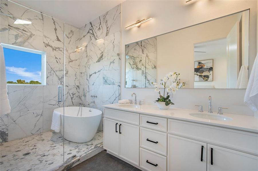 Bathroom featuring a freestanding tub, a marble finish shower, double vanity, and tile walls Bathroom featuring a freestanding tub, a marble finish shower, double vanity, and tile walls