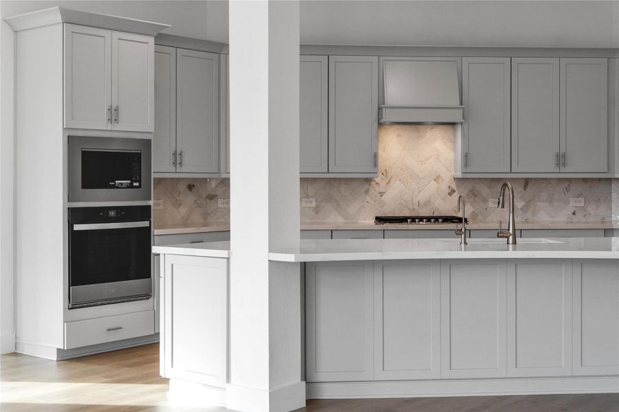 The stunning herringbone tile backsplash serves as a sophisticated focal point, featuring subtle marble-like veining that adds texture and visual depth to the space. The stunning herringbone tile backsplash serves as a sophisticated focal point, featuring subtle marble-like veining that adds texture and visual depth to the space.