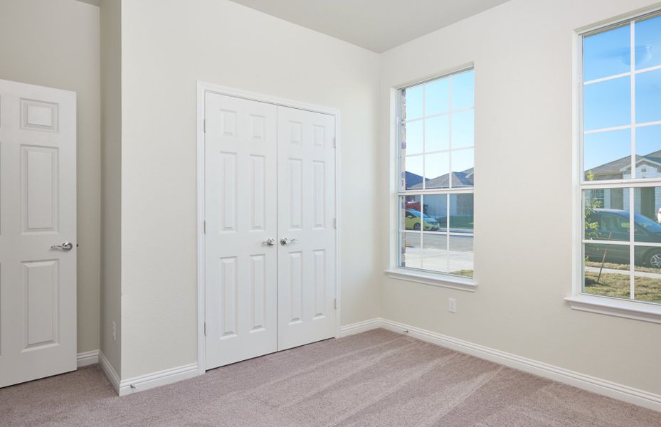 Secondary bedroom with walk-in closet and large windows