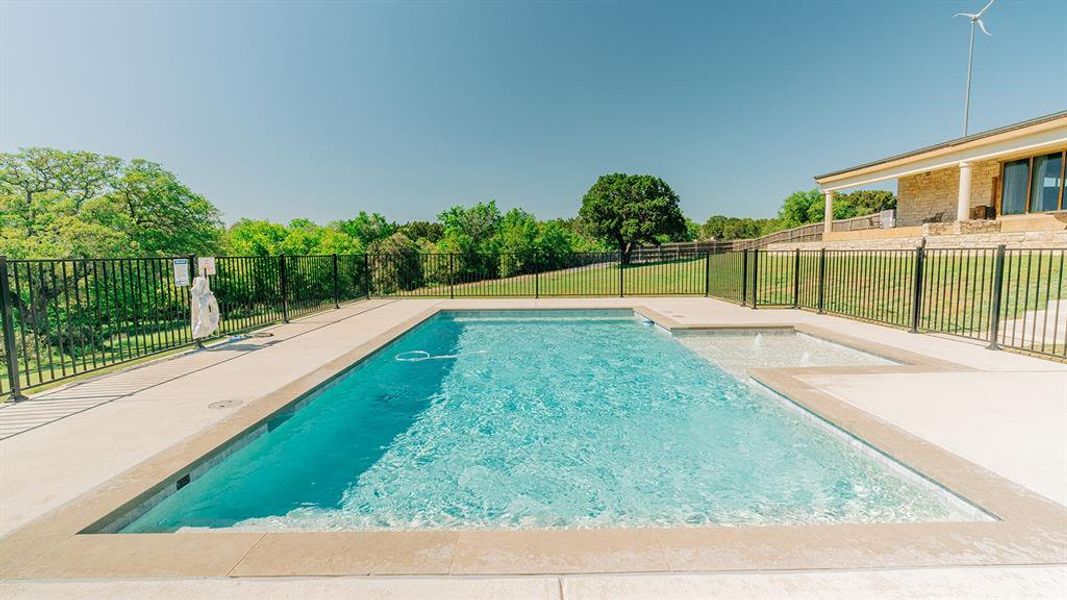 View of pool with a patio area and view of scattered trees
