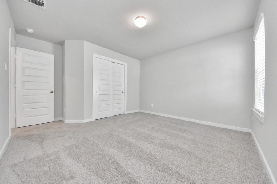 Generously sized secondary bedrooms featuring spacious closets, soft and inviting carpeting underfoot, large windows allowing plenty of natural light, and the added touch of privacy blinds for your personal retreat. Sample photo of completed home with similar floor plan. Actual colors and selections may vary.