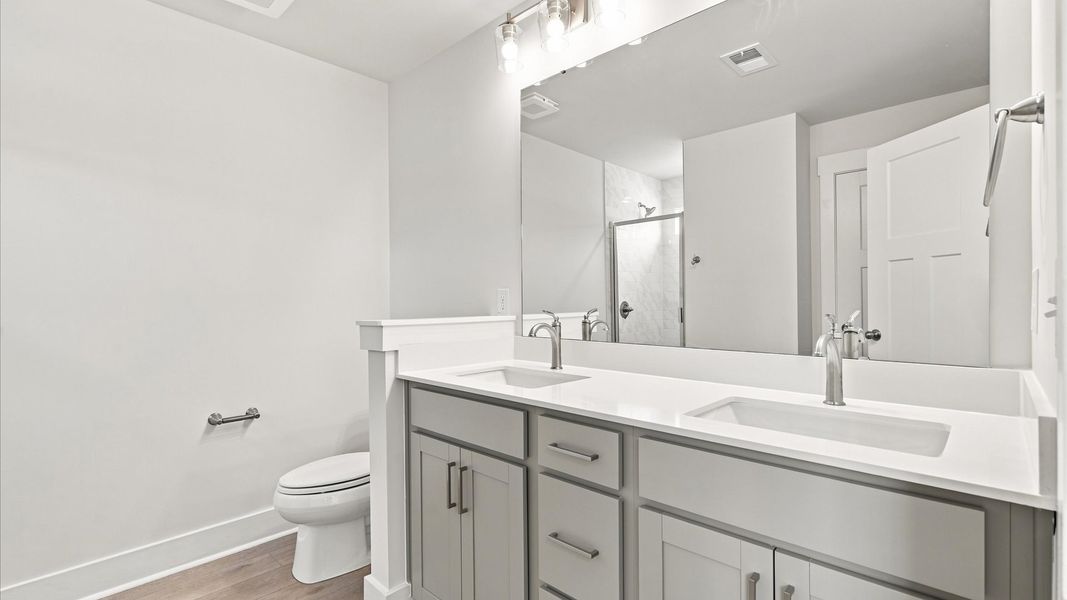 Exceptional en-suite with dual vanity and glass-enclosed tiled walk-in shower for superior everyday comfort