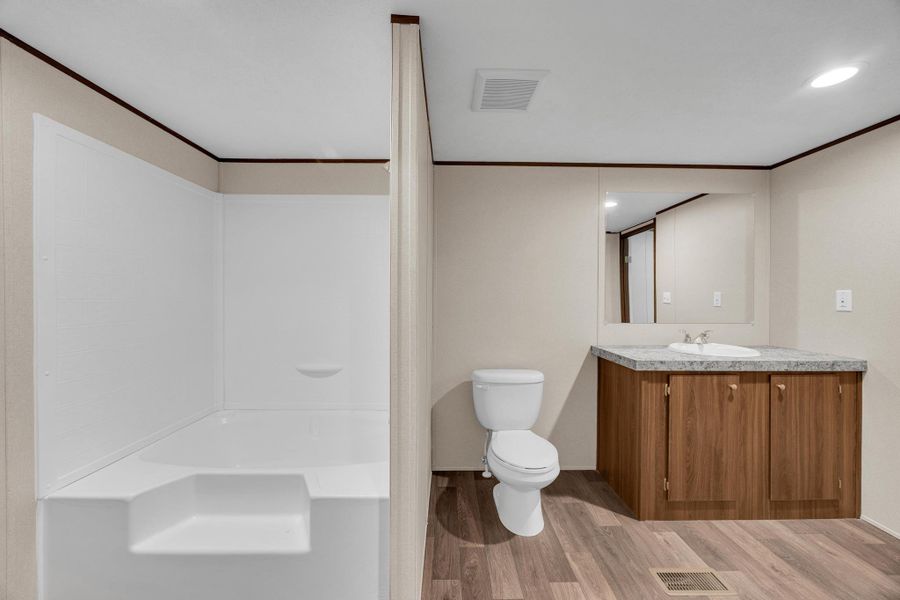 Bathroom featuring vanity, light wood-type flooring, ornamental molding, shower / bath combination, and recessed lighting