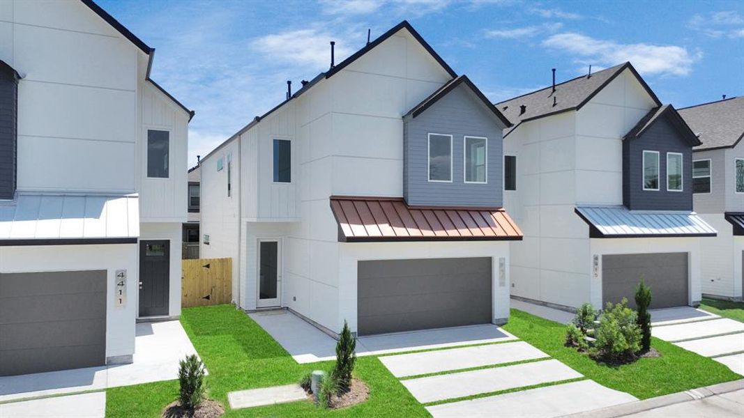 Modern two-story homes featuring clean lines, fresh exterior paint, attached garages, and well-manicured lawns, in a new development near the medical center.