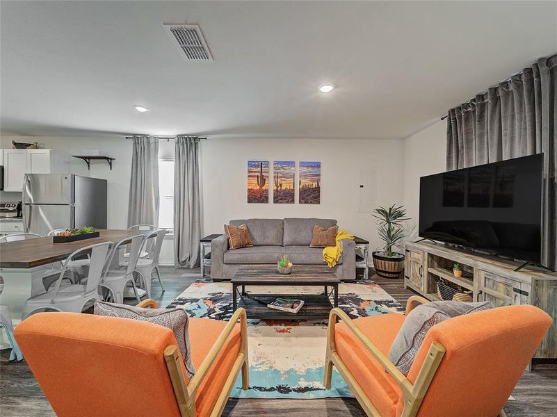 Living room with recessed lighting and dark wood-style flooring