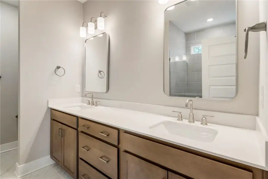 Double vanity with sleek white countertops and ind