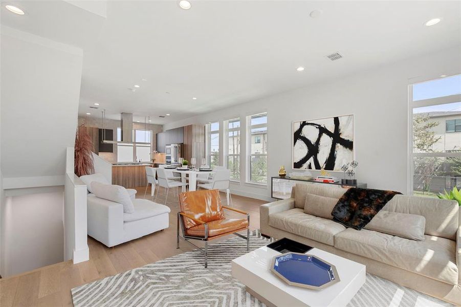 Beautifully lit living room featuring light wood-type flooring