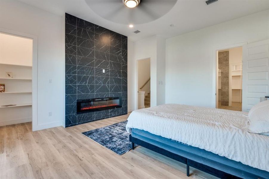 Primary bedroom with stunning Downtown Dallas skyline views, fireplace and a private covered patio featuring a ceiling fan for year-round comfort. Primary bedroom with stunning Downtown Dallas skyline views, fireplace and a private covered patio featuring a ceiling fan for year-round comfort.