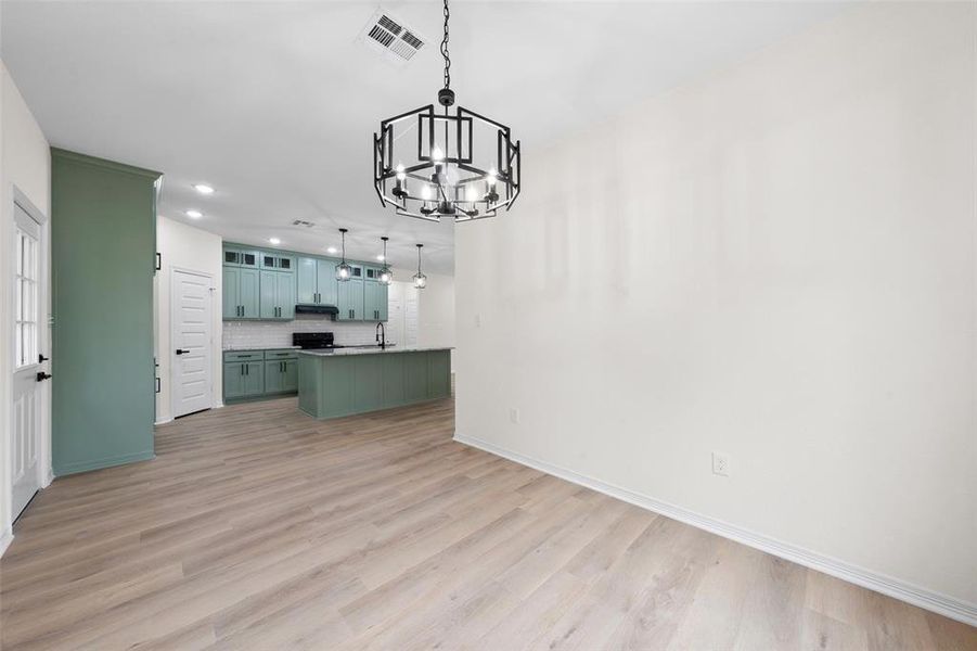 Unfurnished living room with a chandelier, recessed lighting, and light wood finished floors