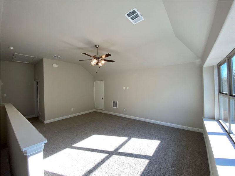 Gameroom upstairs features window seat, ceiling fan, and vaulted ceiling.