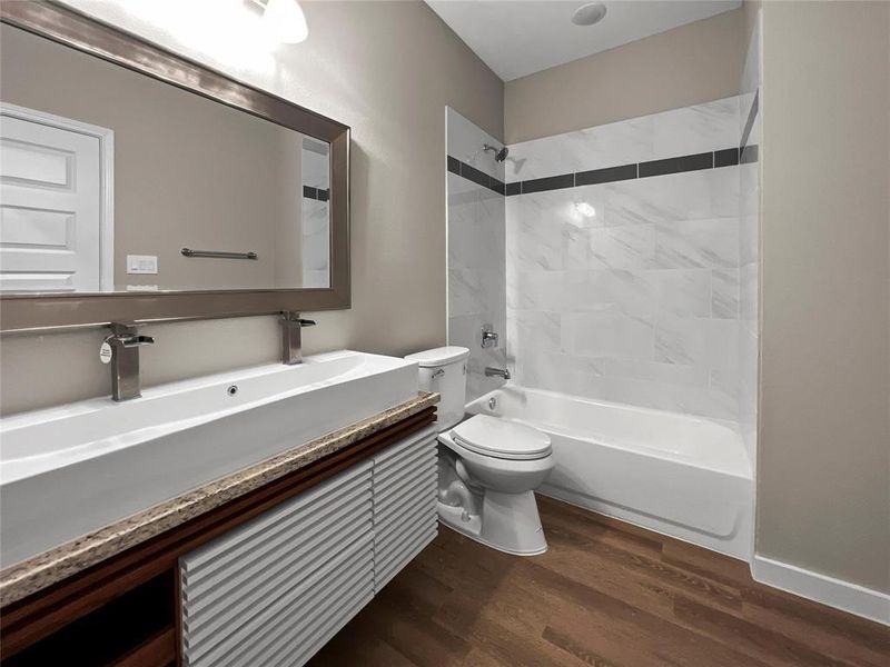 Full bath with wood finished floors, vanity, and bathing tub / shower combination